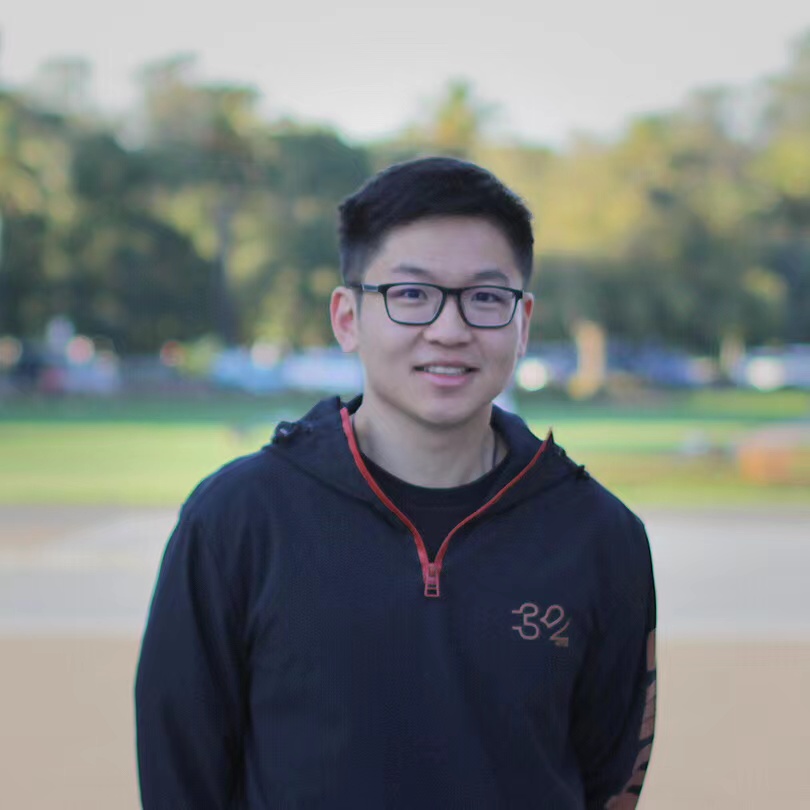 Professional headshot of Perry Li, male architect in business casual attire, standing in modern office environment with laptop and AI development tools visible, bright natural lighting
